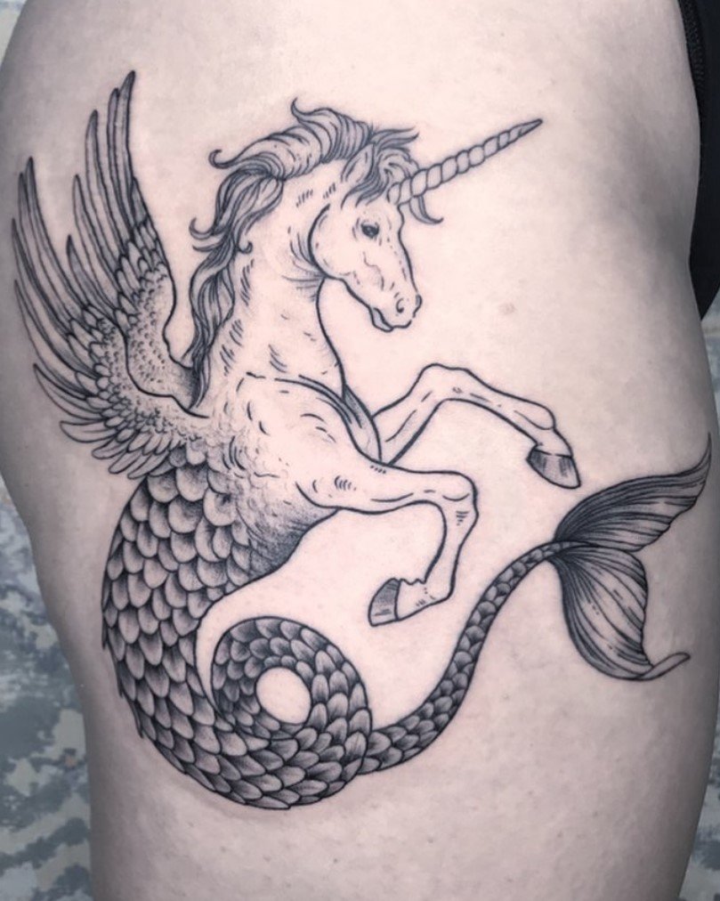 Tatuaggio in stile blackwork a linee sottili, in bianco e nero, di una creatura fantastica per metà unicorno e per metà pesce.Realizzato dall’artista Alice Candy.