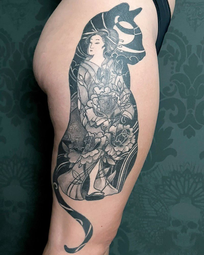 Tatuaggio in bianco e nero raffigurante la sagoma di un gatto nero contenente una geisha giapponese. Realizzato dall’artista Padox Tattoo.